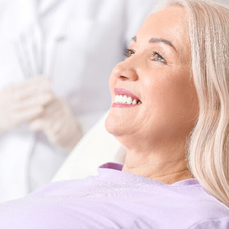older woman smiling while visiting dentist