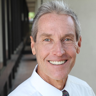 Man with dentures smiling outside
