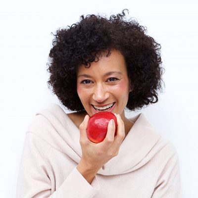 woman biting into a red apple 