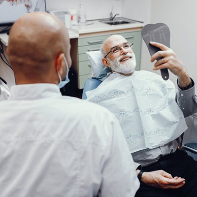patient admiring his new smile with dental implants in Rancho Bernardo 