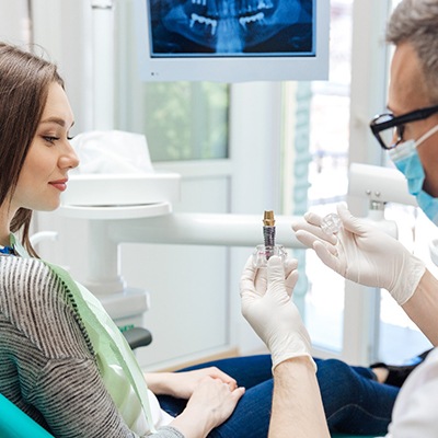 implant dentist in Rancho Bernardo showing a dental implant to a patient 