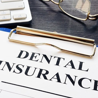 dental insurance form on a blue clipboard 