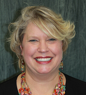 Woman with short blonde hair smilinh