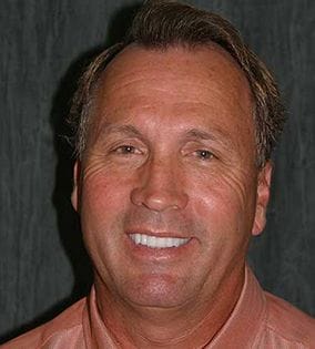 Man in light orange shirt smiling