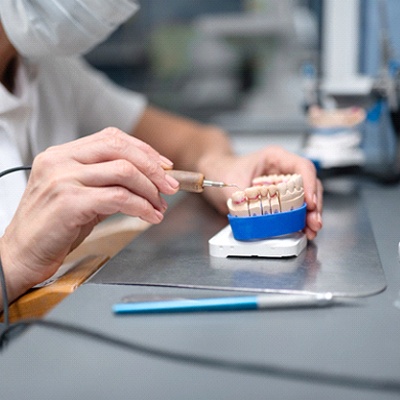 A dental lab technician designing and placing veneers.