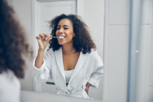 woman brushing her teeth to boost her immune system 