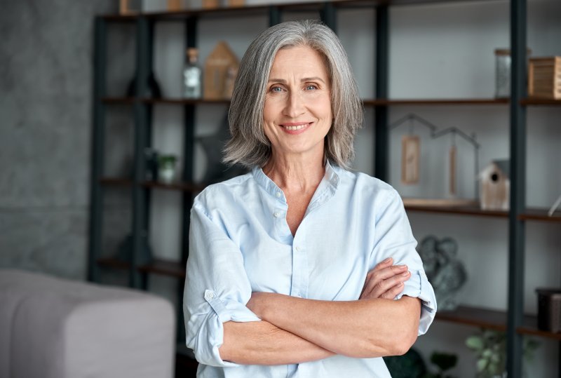 older woman smiling with arms crossed