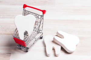 wooden teeth sitting in a miniature shopping cart