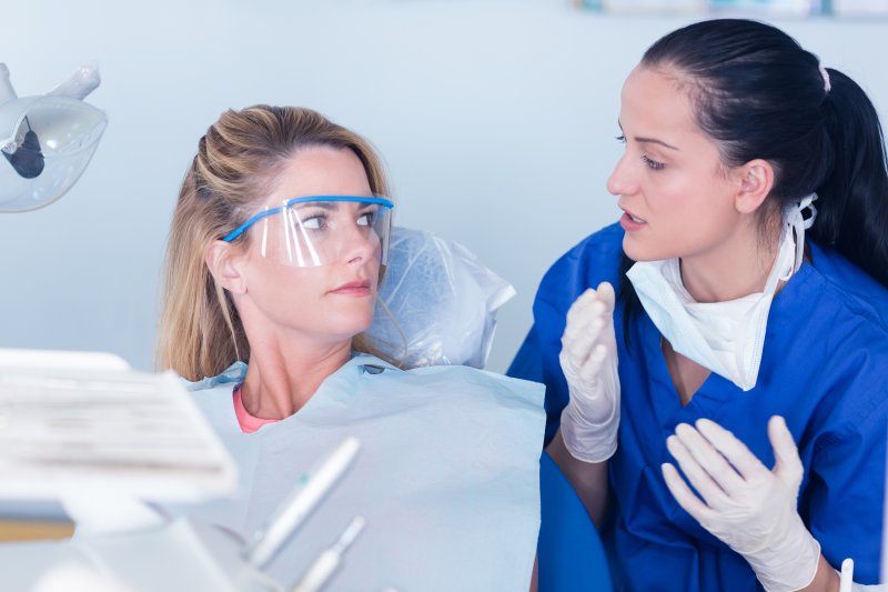 person with morning breath speaking to dentist about it