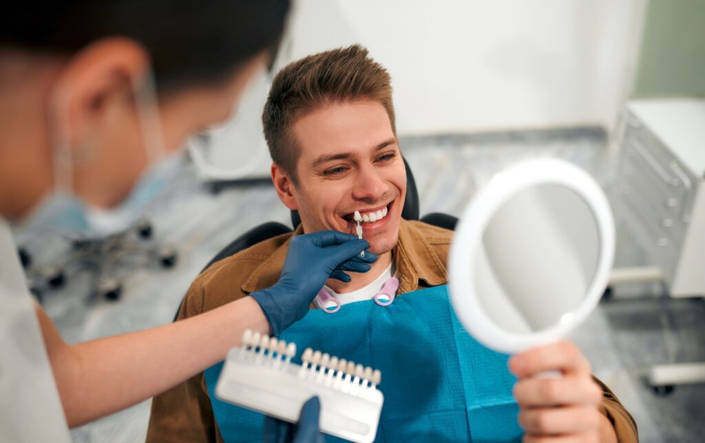 Dentist using shade scale with smiling patient
